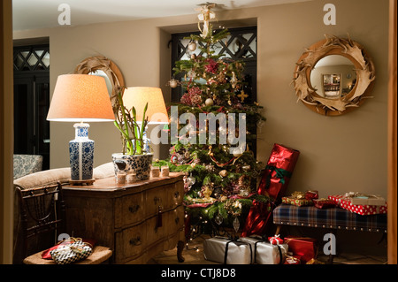 Arbre de Noël dans la salle de séjour avec une décoration bois et miroir à la fois ottoman tartan fait à l'ordre à Réveil chambre coucher Banque D'Images