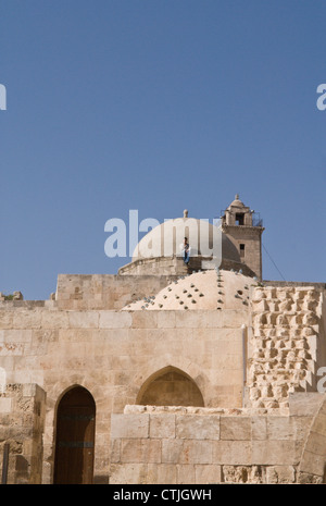 Jeune homme assis sur le toit en dôme d'un édifice à l'intérieur de la Citadelle, Alep, Syrie. Site du patrimoine mondial de l'UNESCO Banque D'Images