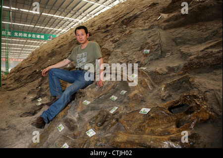Le Dr Xu paléontologue chinois Xing pose parmi les restes de dinosaures de Zhucheng, province de Shandong, Chine. 06-Jun-2012 Banque D'Images