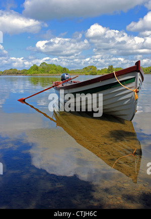 Un bateau à rames se trouve au-dessus de l'eau de Lough Corrib dans le comté de Galway sous un ciel nuageux ciel bleu vif irlandais. Banque D'Images