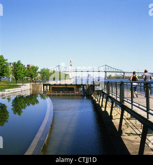 Coureurs les gens qui font du jogging le long du canal de Lachine au printemps et du fleuve Saint-Laurent et qui ont vue sur le pont Jacques-Cartier Montréal Québec Canada KATHY DEWITT Banque D'Images