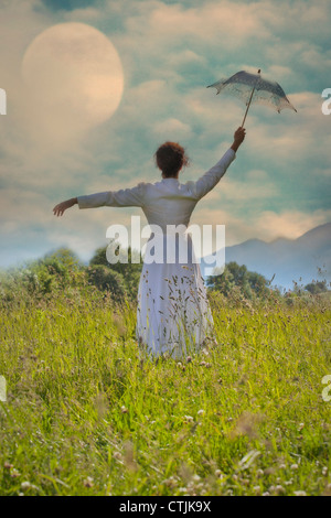 Une femme avec un parasol dans un champ Banque D'Images