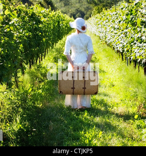 Une femme en blanc, robe victorienne est la marche à travers le vignoble Banque D'Images