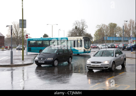 Taxis et d'un bus arriva devant une gare ferroviaire à l'état humide et jour de pluie en Angleterre. Banque D'Images