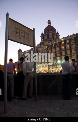Taj Mahal Hotel tourné pendant la nuit avec une pancarte en langue autochtone - lecture 'Mumbai' Hindi Banque D'Images