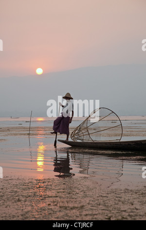 Pêcheur birman au travail faisant la pêche traditionnelle sur le lac Inle au Myanmar (Birmanie). Banque D'Images