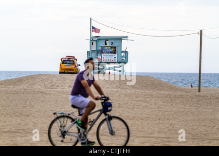 Les cyclistes sur la plage de Santa Monica avec un maître-nageur camion et chambre à l'arrière-plan Banque D'Images