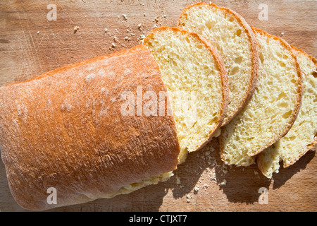 Tranches de pain jaune semoule sicilienne sur planche de bois Banque D'Images