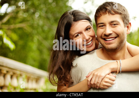 Girl hugging son petit ami, à la fois à la recherche à la cam et souriant Banque D'Images