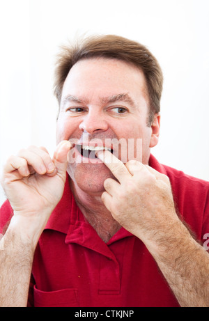 L'homme de la soie dentaire Les dents dans le miroir. Une bonne hygiène buccale. Banque D'Images