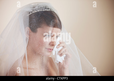 Une jeune épouse d'essuyer les larmes de son visage avec un mouchoir Banque D'Images