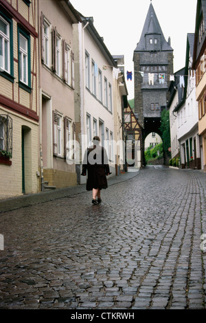 Une femme marche sur rue pavée de Bacharach Allemagne. Banque D'Images