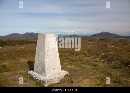 Isle of North Uist, Scotland. Trig point en haut de Beinn Langais à l'est avec l'île Skye dans l'arrière-plan lointain. Banque D'Images