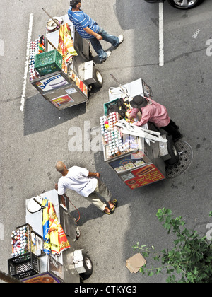 Birds Eye View 3 hot-dog New York les vendeurs de rue en poussant leurs chariots distributeurs 11e Avenue jusqu'aux beaux jours d'été Manhattan Banque D'Images