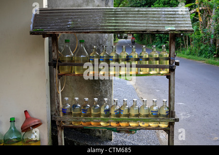 Bouteilles d'essence en vente sur un éventaire. Près de Ubud, Bali, Indonésie. Banque D'Images