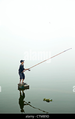 Un pêcheur solitaire sur le lac de l'ouest de la région de Hanoi, Vietnam Banque D'Images