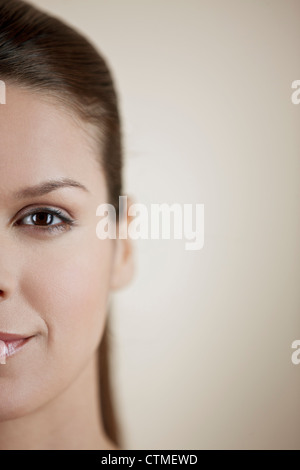 Portrait of a young woman smiling, montrant la moitié gauche de son visage Banque D'Images