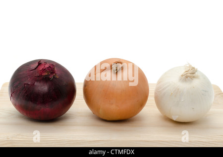 Trois variétés d'oignon frais - rouge, blanc et brun sur une planche à découper en bois, studio shot Banque D'Images