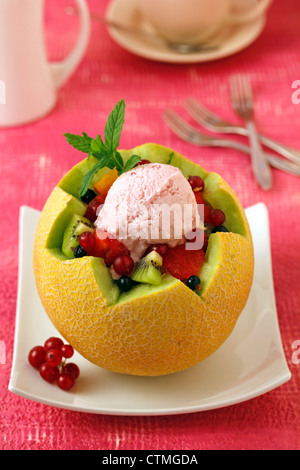 Melon avec les fruits et la crème glacée. Recette disponible. Banque D'Images