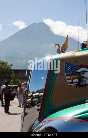 La gare routière d'Antigua avec le volcan Fuego fumeurs dans la distance, au Guatemala, en Amérique centrale Banque D'Images