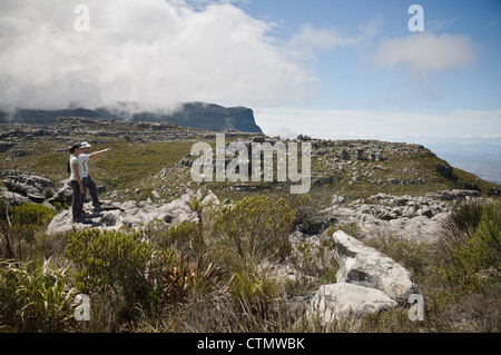 Les randonneurs des jeunes adultes (hommes et femmes) Comité permanent sur la roche, le Parc National de Table Mountain, Cape Town, Western Cape, Afrique du Sud Banque D'Images