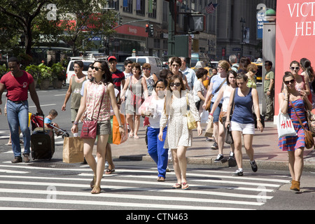 Les piétons attendent pour traverser à 34th Street et Avenue à New York. Banque D'Images