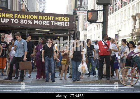 Les piétons attendent pour traverser à 34th Street et Avenue à New York. Banque D'Images