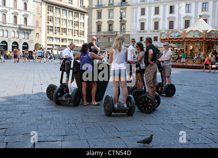 Groupe de touristes sur les machines Segway l'écoute de leur guide dans la Piazza Reppublica, Florence, Italie Banque D'Images