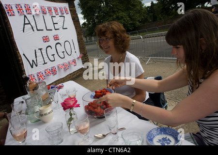 Spectateurs savourer un dessert de fraises aux côtés de leurs bannières de fortune à l'équipe Go's road cycling hero Bradley Wiggins, un récent vainqueur du legedary Tour de France. C'est le premier jour de compétition de l'Olympique de Londres 2012 250km course sur route des hommes. À partir du centre de Londres et le passage du capital des sites célèbres avant de partir dans l'Angleterre rurale à l'épuisant fort Hill dans le comté de Surrey. Banque D'Images