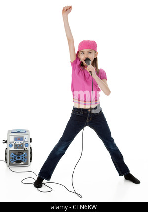 Studio photo pleine longueur de young girl holding microphone devant la machine de karaoké, sur fond blanc. Banque D'Images