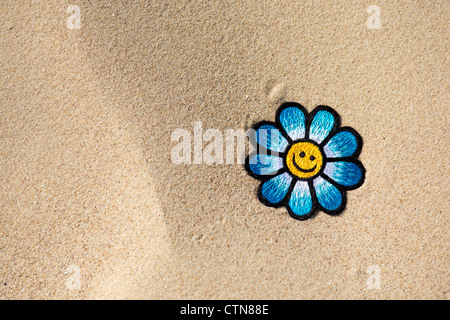 Broderie multicolore sur fer flower patch Smiley en sable d'une plage Banque D'Images