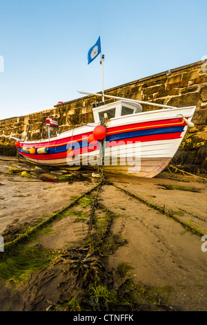 Petit bateau de pêche mored à Scarborough le port à marée basse Banque D'Images