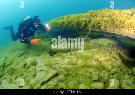 Diver examine une ancienne arme trouvés sous l'eau. Le lac Baïkal, en Sibérie, la Fédération de Russie, de l'Eurasie. Banque D'Images