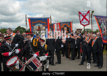 Bannières Orange hissé, musiciens et membres de l'Orange prêt à rejoindre le douzième Juillet parade à Ballynahinch, Co vers le bas. Banque D'Images