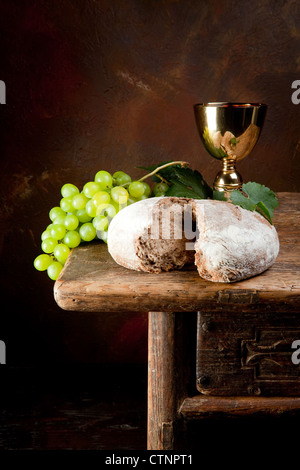 Vin sacré calice avec des raisins et du pain consacré Banque D'Images