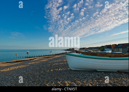 Afficher le long de Selsey beach près de sunset avec petits bateaux établi sur les galets Banque D'Images