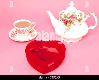 Un os chine théière et tasse et soucoupe rouge avec une boîte de chocolats en forme de coeur - Studio shot Banque D'Images