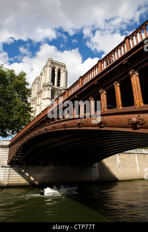Une croisière en bateau sous un pont par la Cathédrale Notre Dame sur la Seine, à Paris, France Banque D'Images