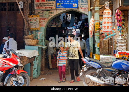 Les piétons du shopping dans les magasins avec allée occupé à vendre des marchandises dans la rue dans la vieille ville de Delhi, Inde Banque D'Images