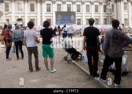 Spectateurs regarder la TV en direct de la couverture de l'événement de l'équipe de plongée avec les athlètes GO Tom Daley et Pete Waterfield à l'Old Royal Naval College de Greenwich, au jour 4 des Jeux Olympiques de 2012 à Londres. Greenwich Park est l'hôte du concours Équestre Olympique, plus la course et de l'épreuve de tir Pentathlon moderne. L'Old Royal Naval College est la pièce maîtresse de l'architecture Maritime Greenwich, Site du patrimoine mondial dans la région de Greenwich, Londres. Banque D'Images