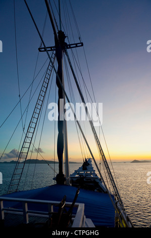 Lever du soleil à bord du 108 'pied Ombak Putih", une goélette Phinisi traditionnel cruising dans la région de Nusa Tenggara en Indonésie. Banque D'Images