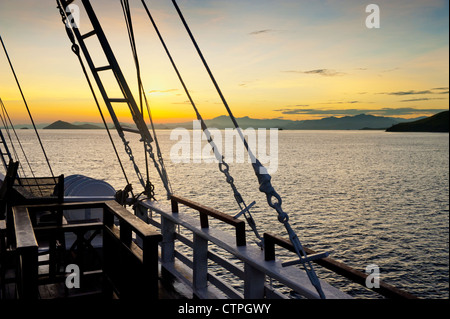 Lever du soleil à bord du 108 'pied Ombak Putih", une goélette Phinisi traditionnel cruising dans la région de Nusa Tenggara en Indonésie. Banque D'Images