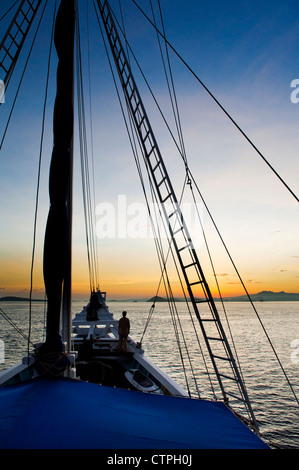 Lever du soleil à bord du 108 'pied Ombak Putih", une goélette Phinisi traditionnel cruising dans la région de Nusa Tenggara en Indonésie. Banque D'Images