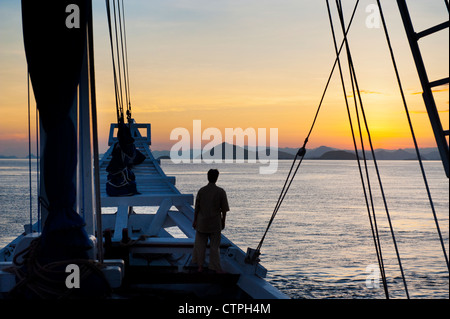 Lever du soleil à bord du 108 'pied Ombak Putih", une goélette Phinisi traditionnel cruising dans la région de Nusa Tenggara en Indonésie. Banque D'Images