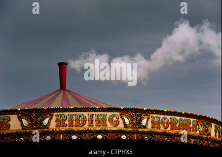 La vapeur ou la fumée s'échappant de la cheminée sur un vieux vapeur fairground merry-go-round. Banque D'Images