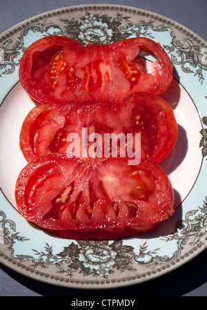 Tranches de Tomates Rose géant (Zapotec Pleated) sur la plaque Banque D'Images