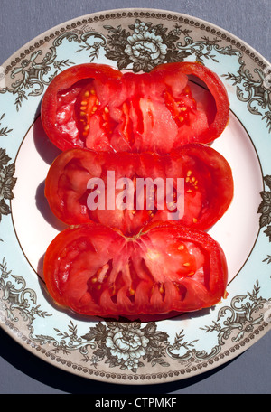 Tranches de Tomates Rose géant (Zapotec Pleated) sur la plaque Banque D'Images