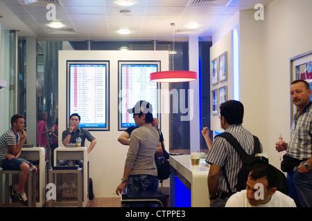 Les passagers de l'air vous détendre avec des cigarettes dans l'un des nombreux fumeurs à l'aéroport international de Dubaï Banque D'Images