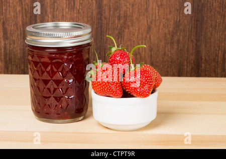 Confiture de fraises fraîches ou la gelée avec bol de fraises sur table en bois Banque D'Images