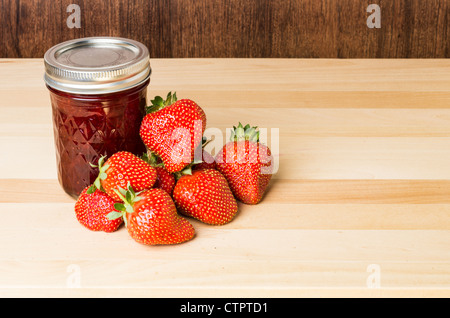 Fraises fraîches avec de la confiture de fraise ou de gelée sur la table en bois Banque D'Images